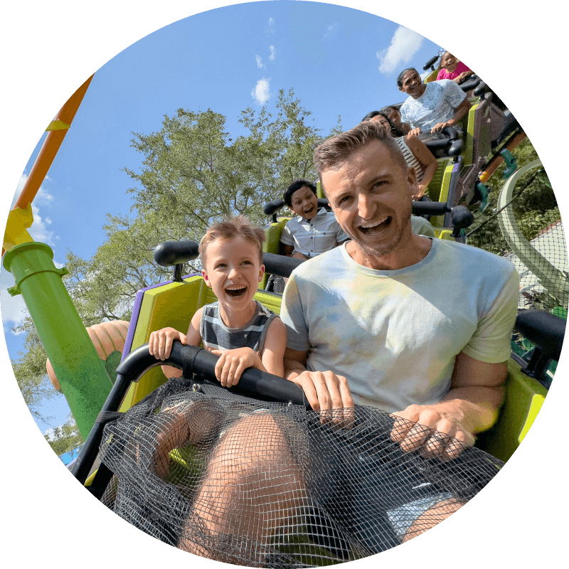 Guests smiling in excitement as they ride the Trolls Coaster in DreamWorks Land.