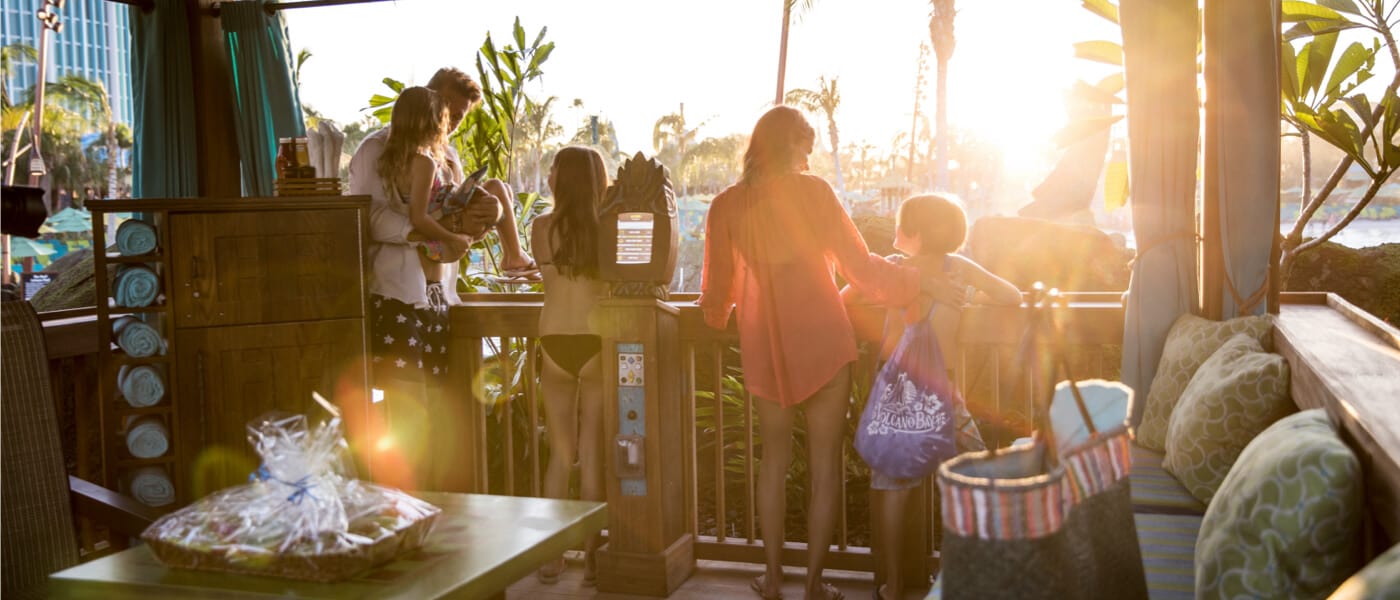 A family of 5 looks out at Universal's Volcano Bay from their spacious, furnished private cabana.