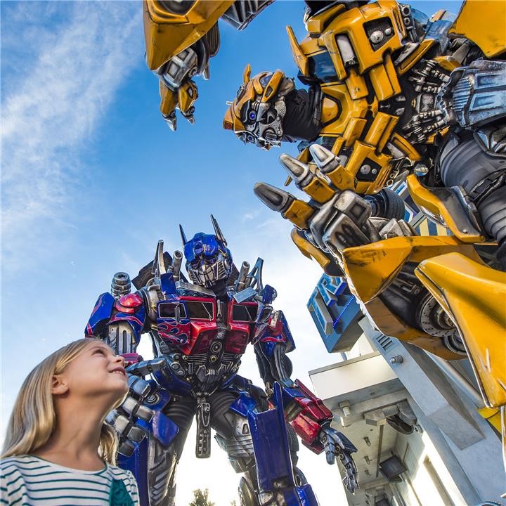 Look up to some of your favourite heroes, including Bumblebee and Optimus Prime, at Universal Studios Florida in Orlando. Towering Bumblebee and Optimus Prime bend down to greet a young girl at Universal Studios Orlando.
