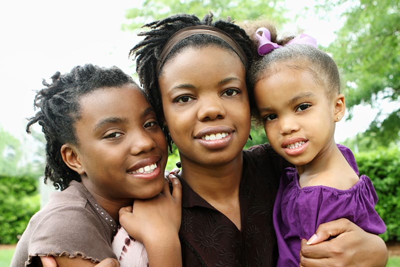 Mother smiling with her two daughters.