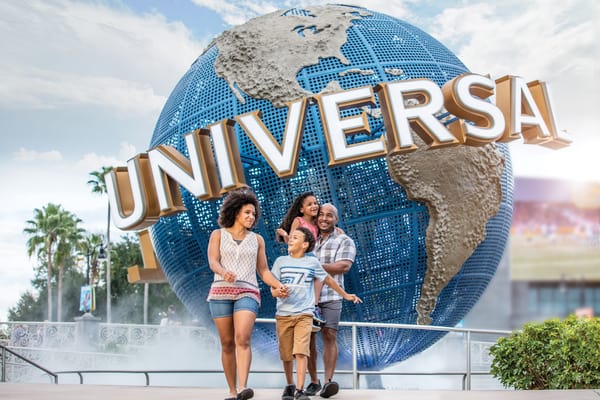 Family of four walking toward the Universal Studios Florida arch park entrance.