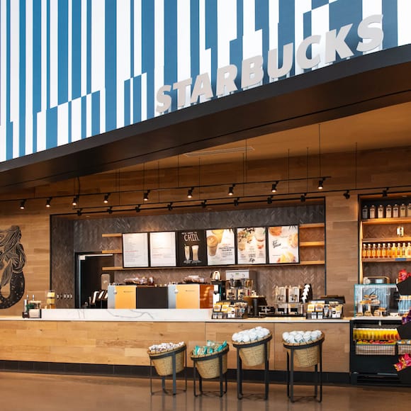 A modern, wood-grained coffee counter with stylized mermaid mural at Starbucks in Universal's Aventura Hotel in Universal Orlando Resort.