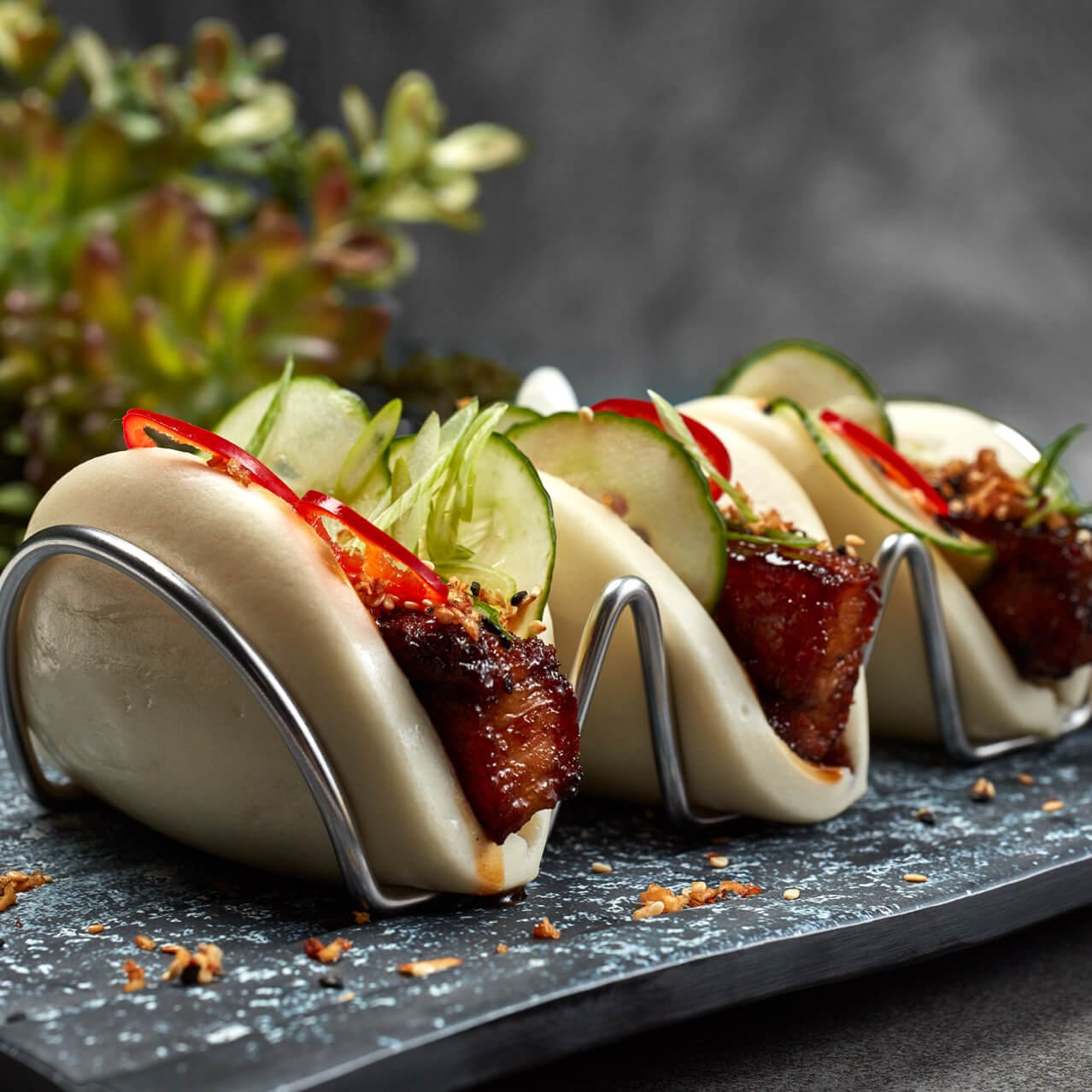 Three Chinese bao buns filled with pork belly and vegetables from Bar 17 Bistro at Universal Orlando’s Aventura Hotel.