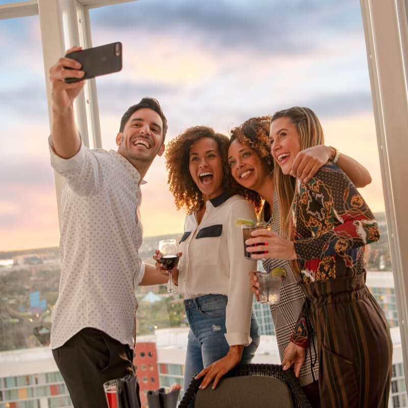 A group of friends take a selfie from the rooftop bar of Universal Aventura Hotel.