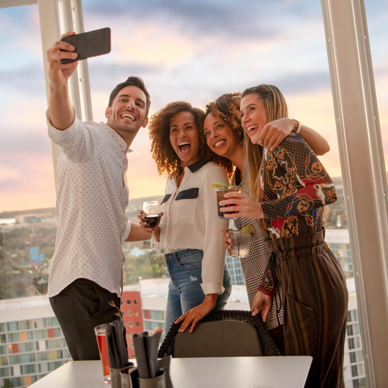 A group of friends take a selfie from the rooftop bar of Universal Aventura Hotel.
