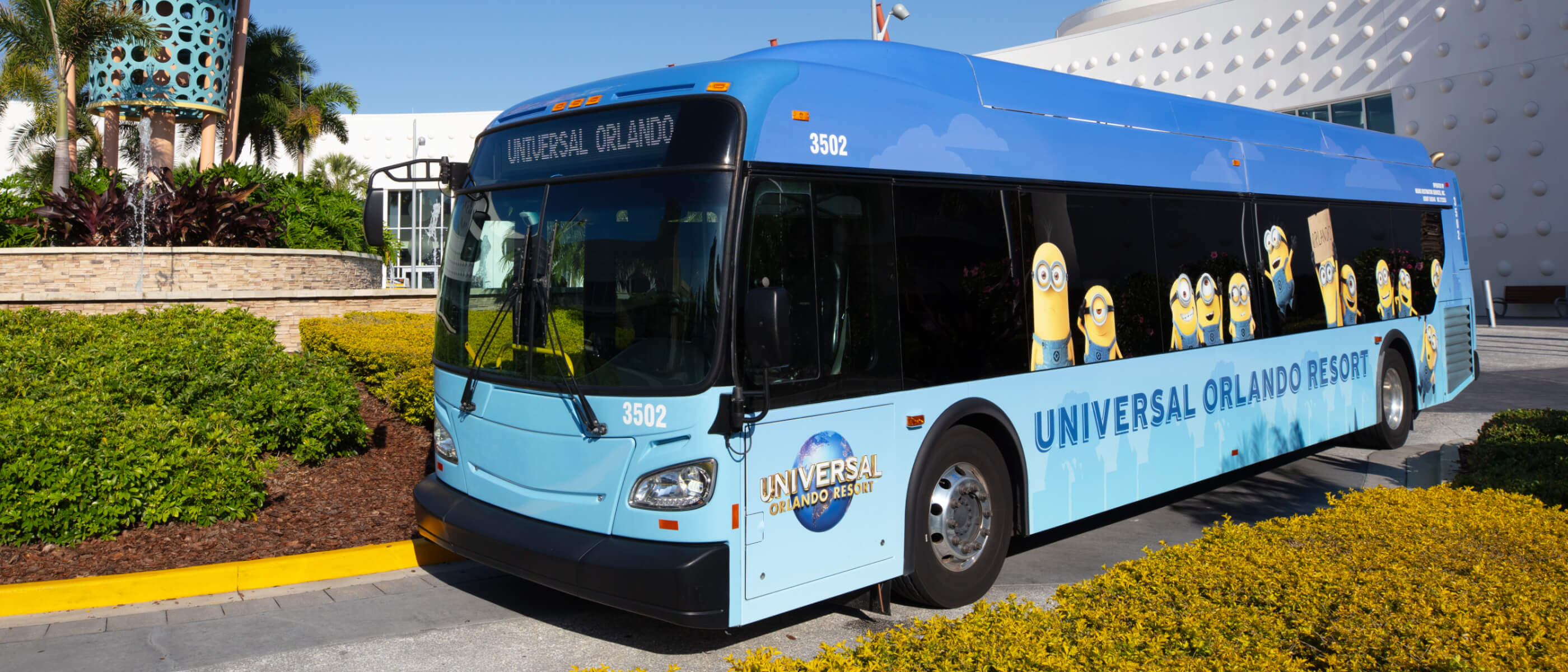 A light blue “UNIVERSAL ORLANDO RESORT” bus with various Minions depicted on the side windows.