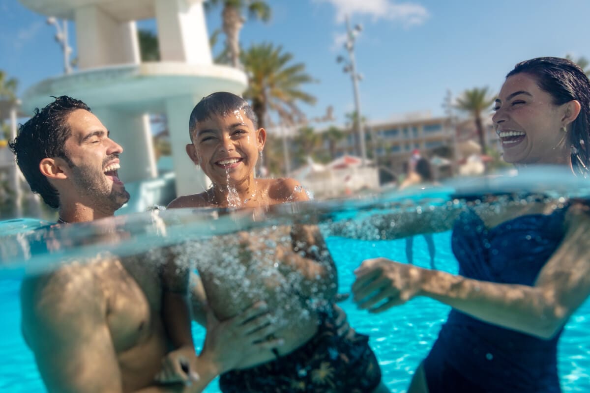 A family laughing and playing in the pool at Universal Cabana Bay Beach Resort.
