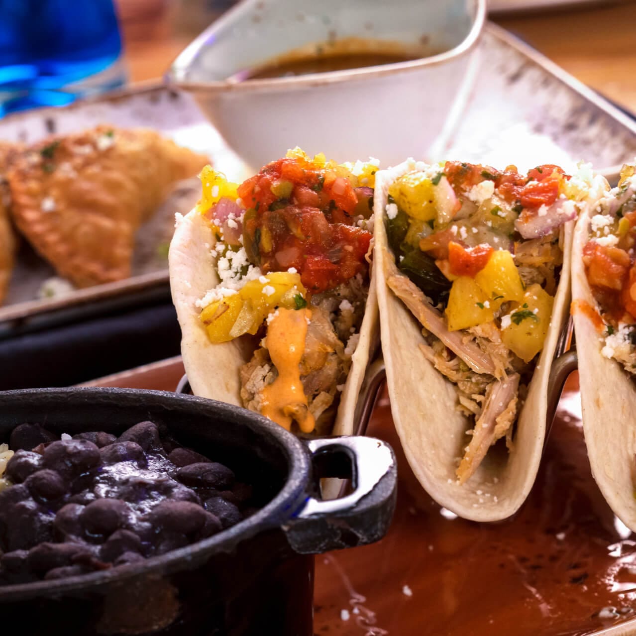 Fresh tacos beside a bowl of black beans at Antojitos Authentic Mexican Food restaurant in Universal CityWalk