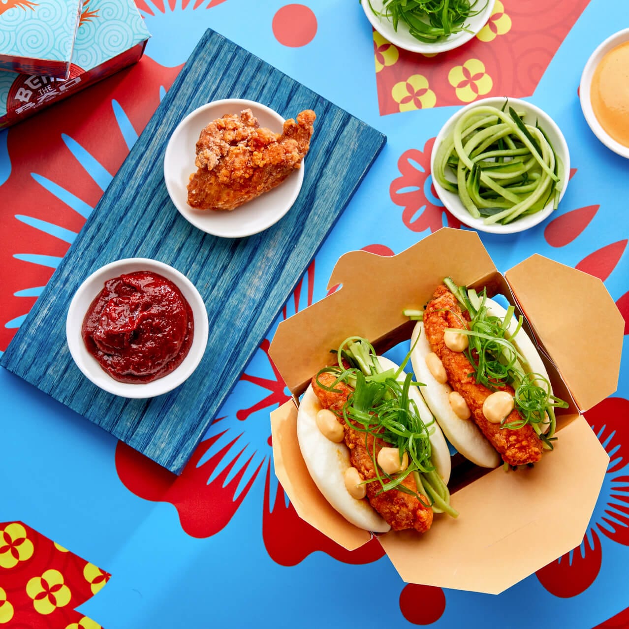 Kimchee Fried Chicken baos with side sauces and food samples at Bend the Bao restaurant in Universal CityWalk.