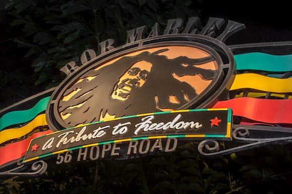The sign at the entryway to Bob Marley A Tribute to Freedom features an image of Bob's face surrounded by red, yellow, and green colors.