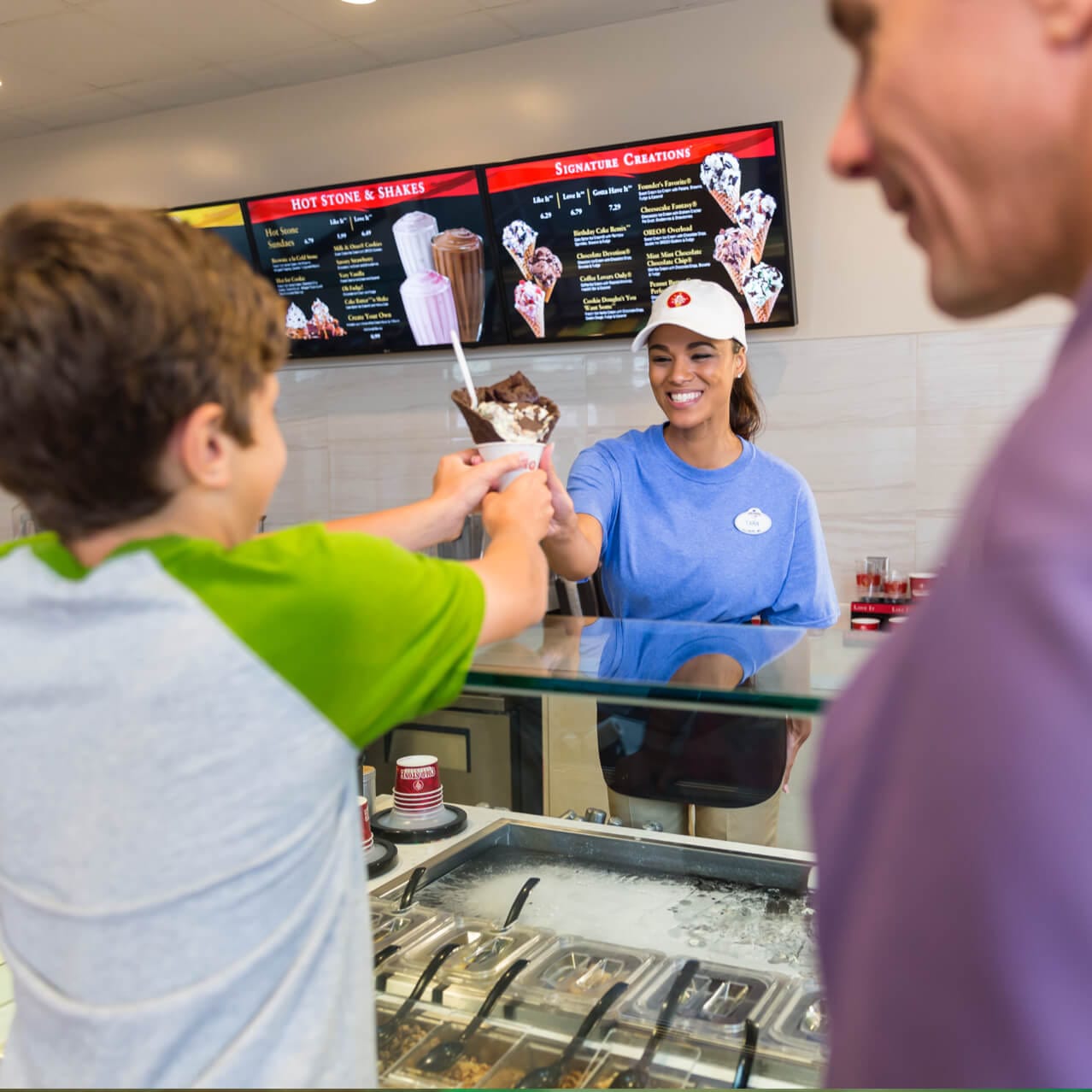 A Cold Stone Creamery employee hands a young boy a waffle cone at Universal CityWalk.