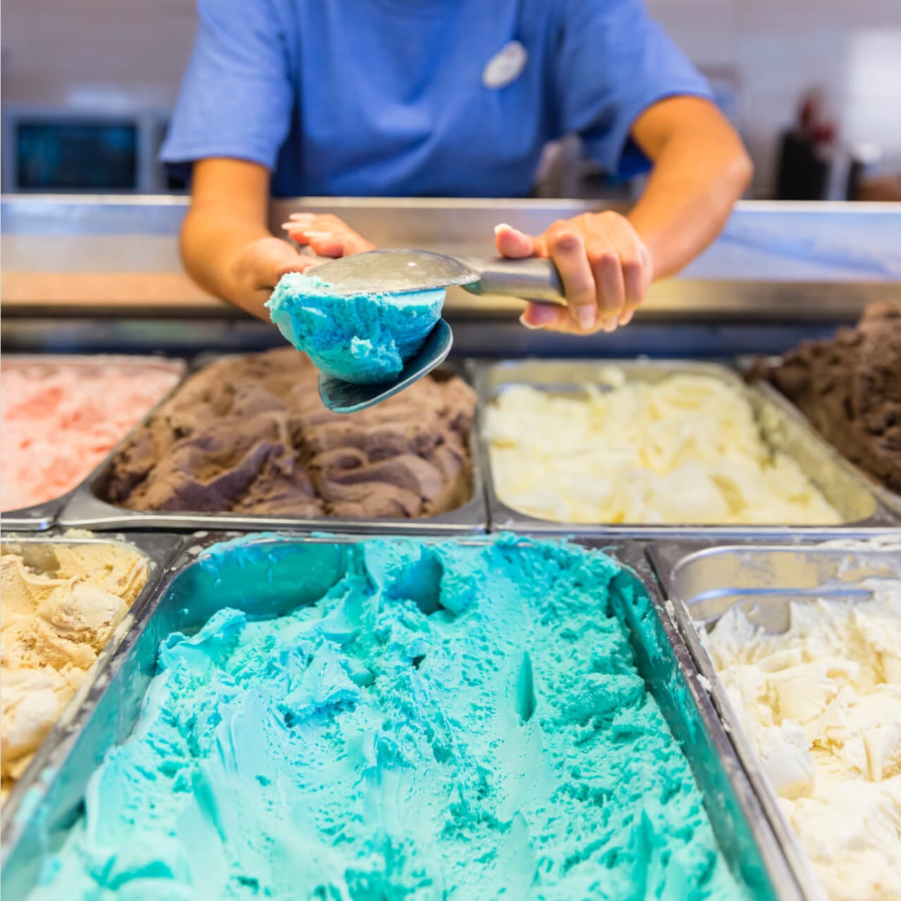 A Cold Stone Creamery employee scoops up bright blue ice cream at Universal CityWalk.