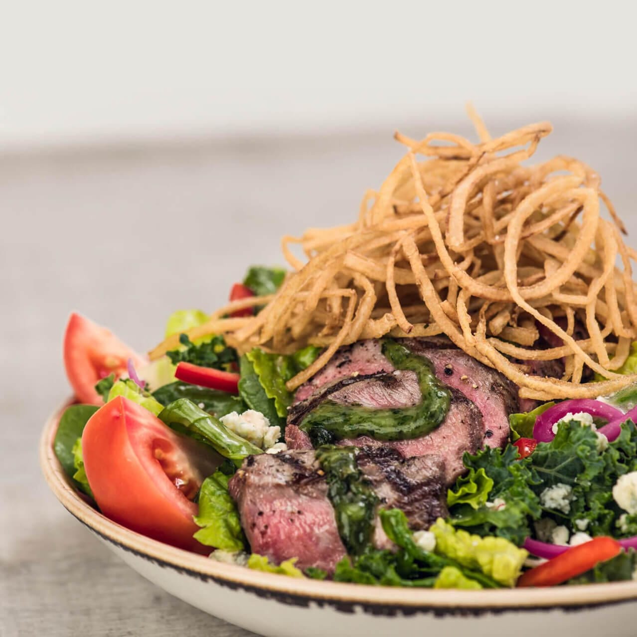 Hard Rock Cafe’s steak salad topped with shoestring onions and blue cheese.