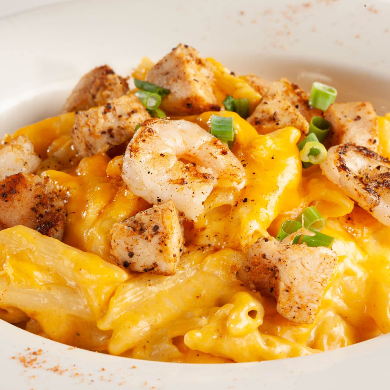 Pat O’Brien’s Cajun Mac N Cheese plate at CityWalk Orlando, featuring Penne pasta, blackened chicken and shrimp with a Cajun cheese sauce.