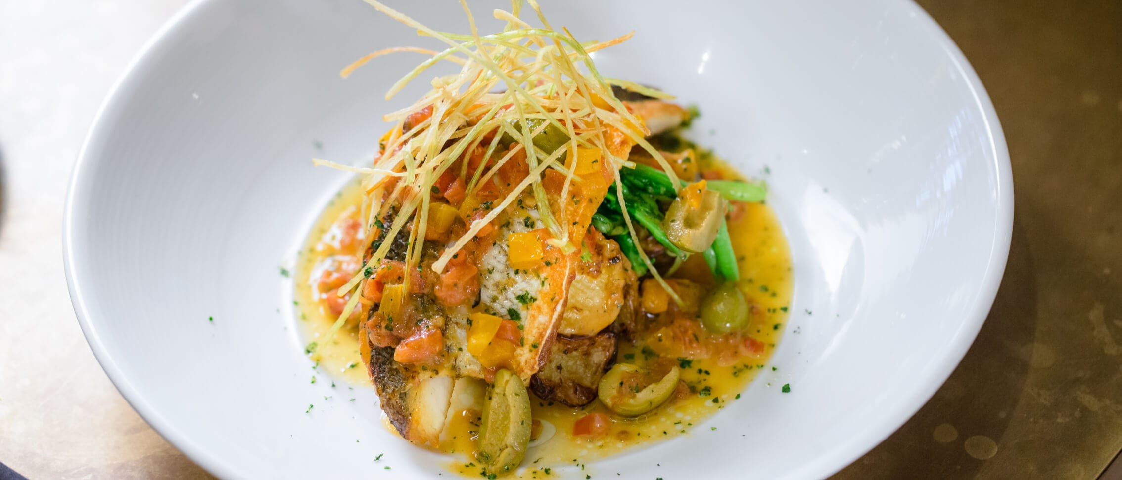 An elegant salmon dish accented with olives and tomatoes from Vivo Italian Kitchen at Universal CityWalk.