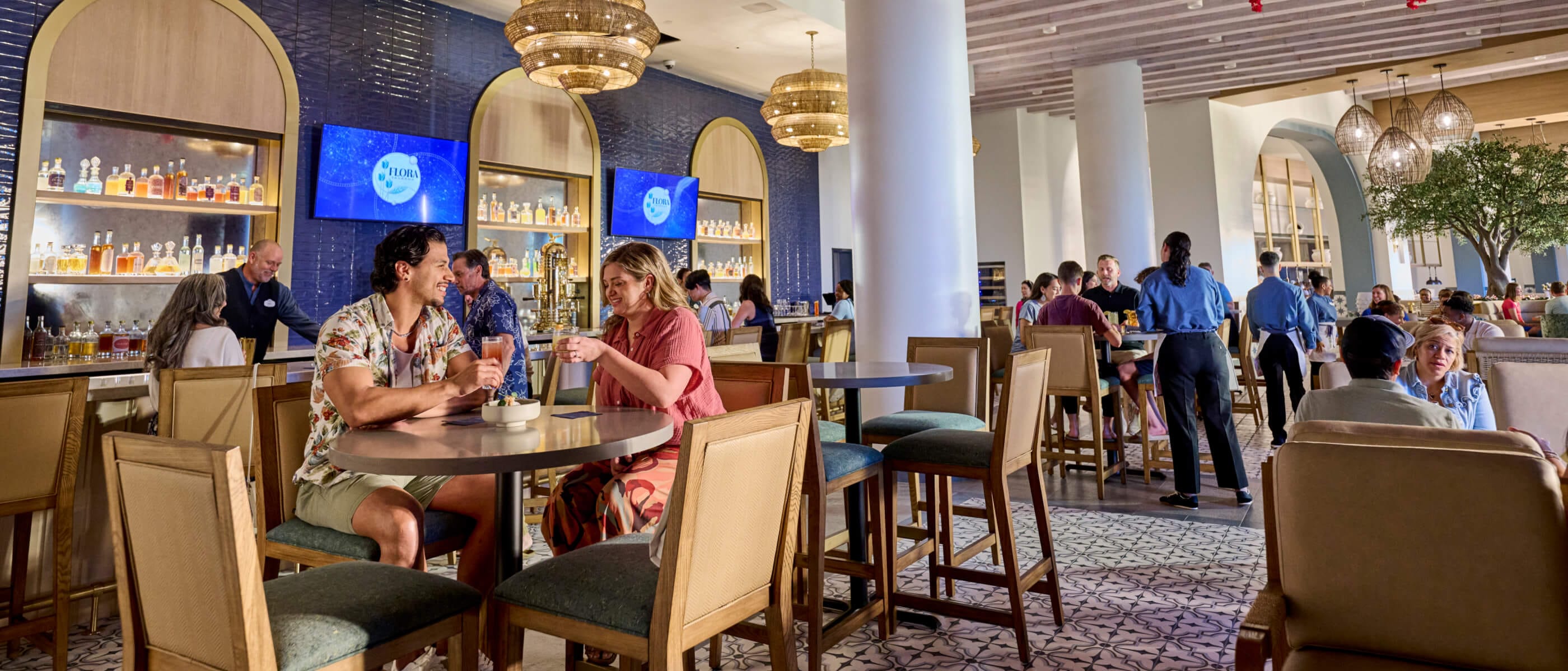Guests enjoying a meal in Flora Taverna, inside Universal Helios Grand Hotel, a Loews Hotel.