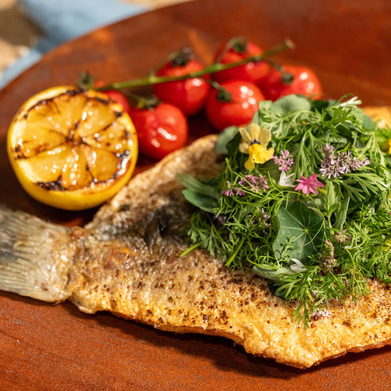 Whole Branzino served with pickled green tomato gribiche, fresh citrus, and chermoula (Moroccan Herb Sauce) at Flora Taverna.
