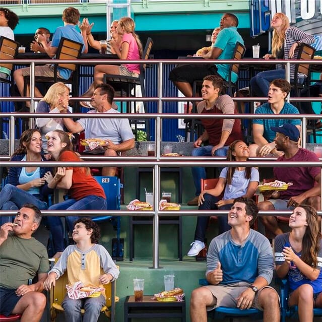Guests sit on authentic ballpark seats in a section of the outdoor dining area for the Hot Dog Hall of Fame at Universal CityWalk.