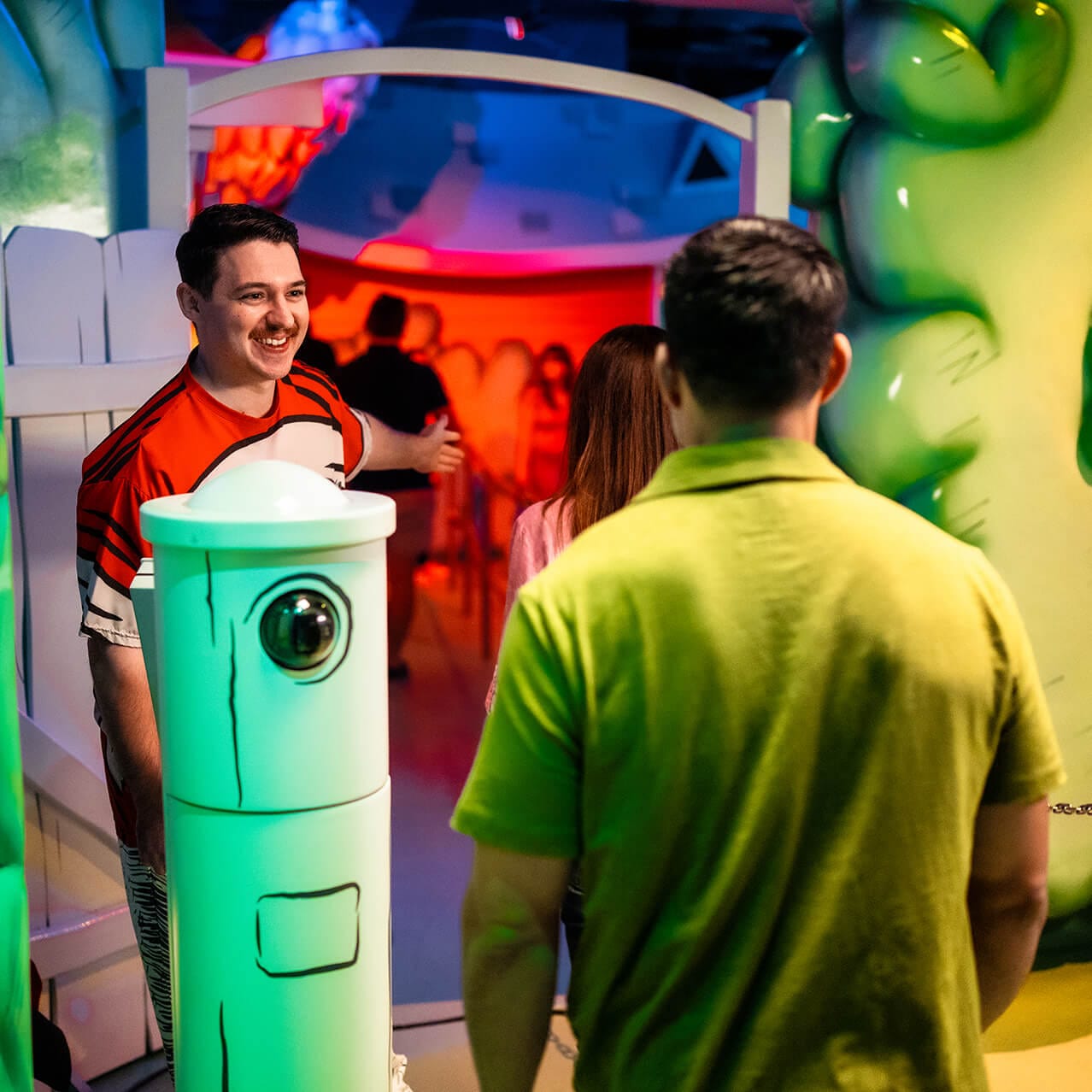  A smiling Team Member directing a guest to enter The Cat in The Hat™ at Universal Islands of Adventure.