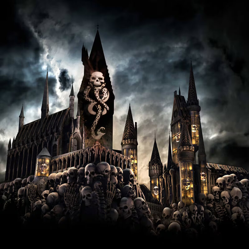 A rendering of Hogwarts castle surrounded by skulls with the Dark Mark projected on it under a dark, cloudy night sky.