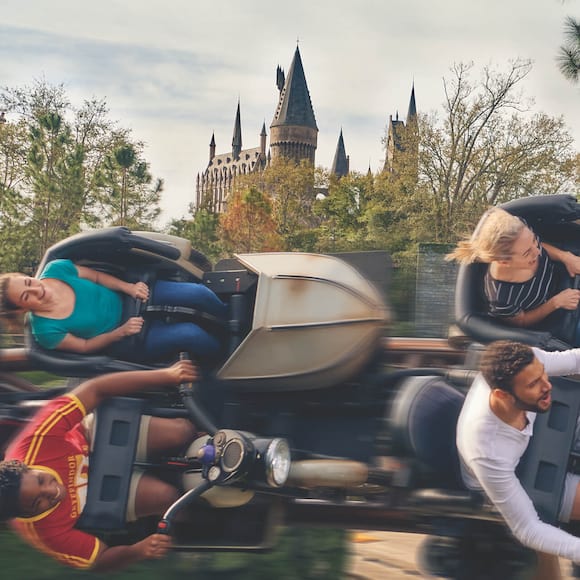 Hagrid's Magical Creatures Motorbike Adventure™ flies by with Hogwarts™ castle in the background.