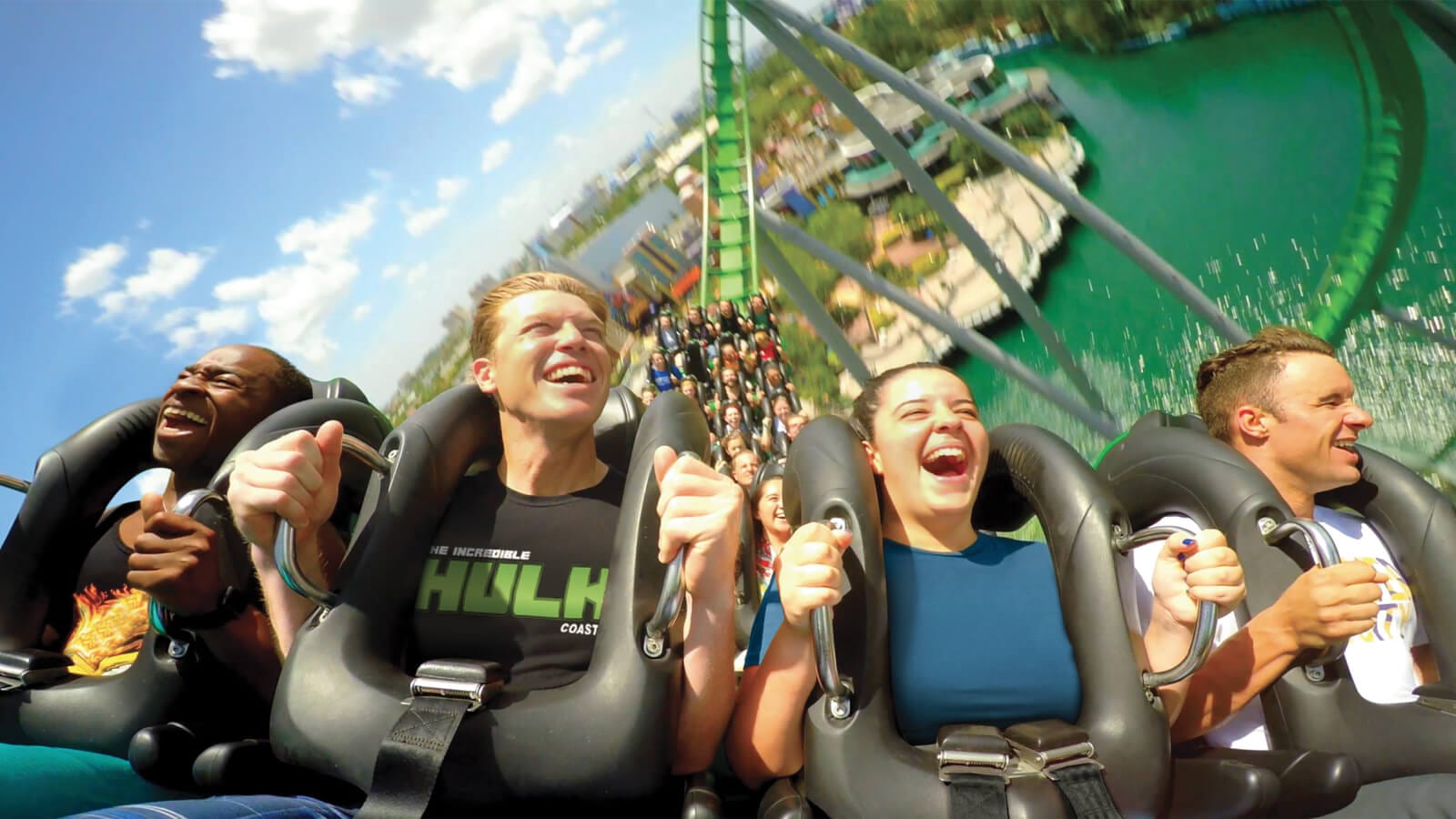 Close up of guests smiling while riding the Incredible Hulk roller coaster at Universal’s Islands of Adventure.