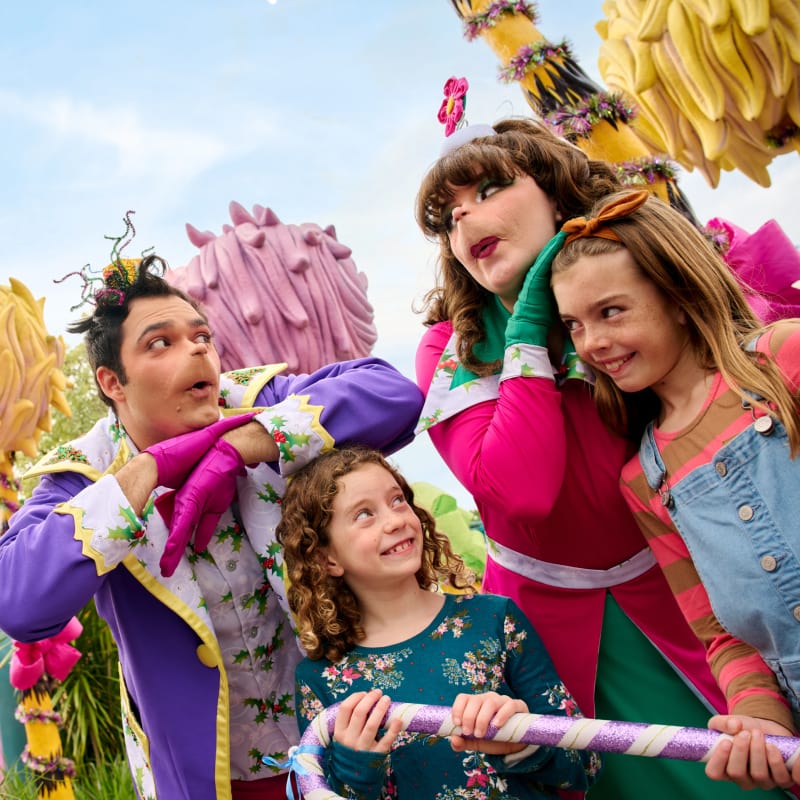 The Whos making mischievous facial expressions with two girls in with Seuss Landing at Universal Islands of Adventure.