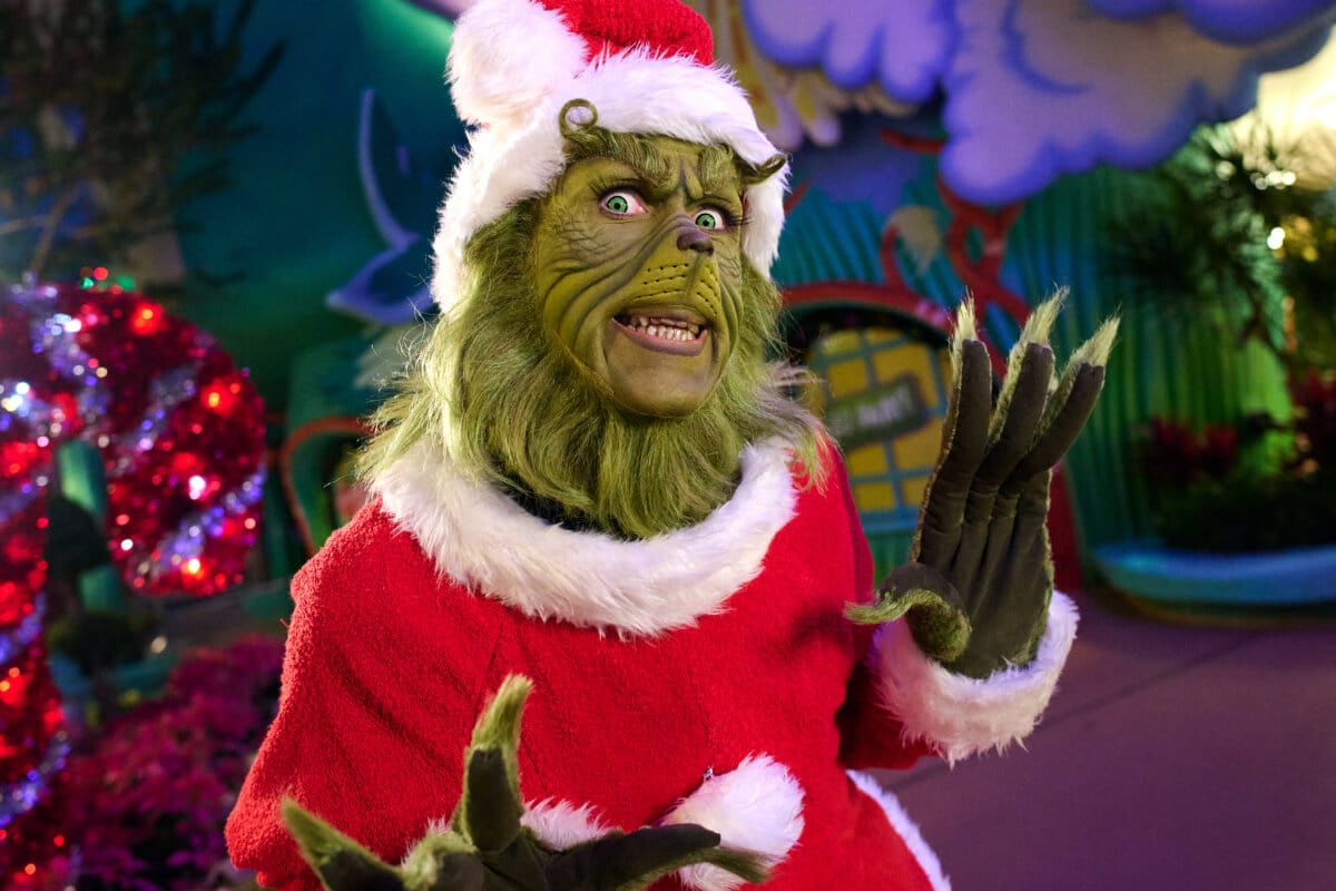 The Grinch dressed up as Santa with Christmas decorations at Seuss Landing in Universal Islands of Adventure.