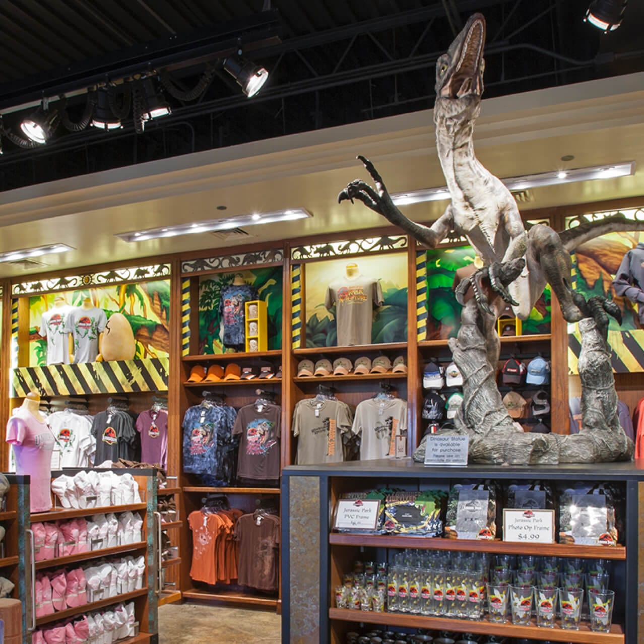 Walls and shelves filled with colorful Jurassic Park themed clothing, toys, dinosaur figurines, and other gifts at Jurassic Park Outfitters in Universal Orlando.