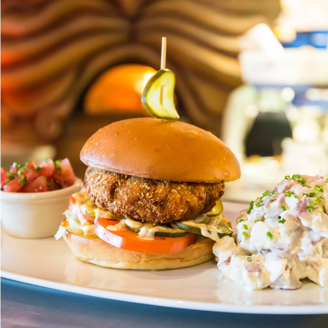 A sandwich with salsa and potato salad sides from Mythos Restaurant.