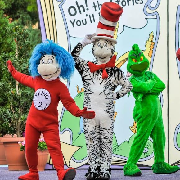 The Cat in the Hat, The Grinch, Thing One and Thing Two, and other characters from Oh! The Stories You'll Hear! pose onstage in front of a giant story book.
