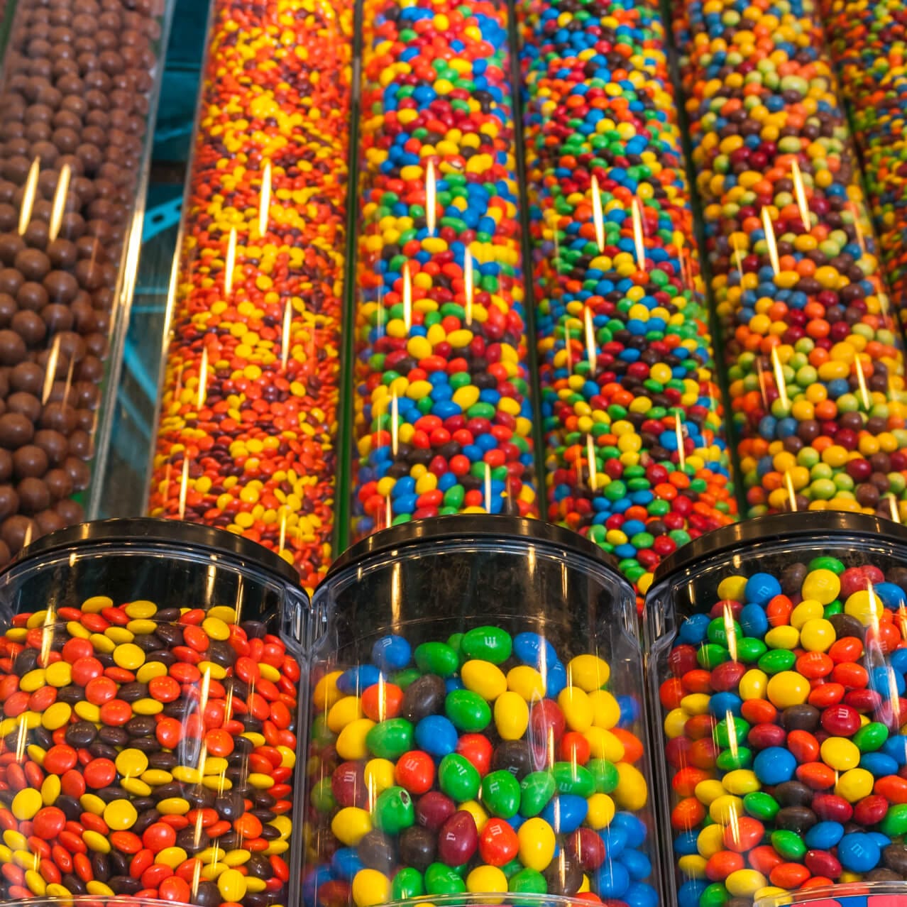 Rows of delectable bulk candies, including candy coated chocolate pieces, peanut butter sweets, and malted milk balls, line the walls of Snookers and Snookers Sweet Candy Cookers in the Seuss Landing area of Islands of Adventure.
