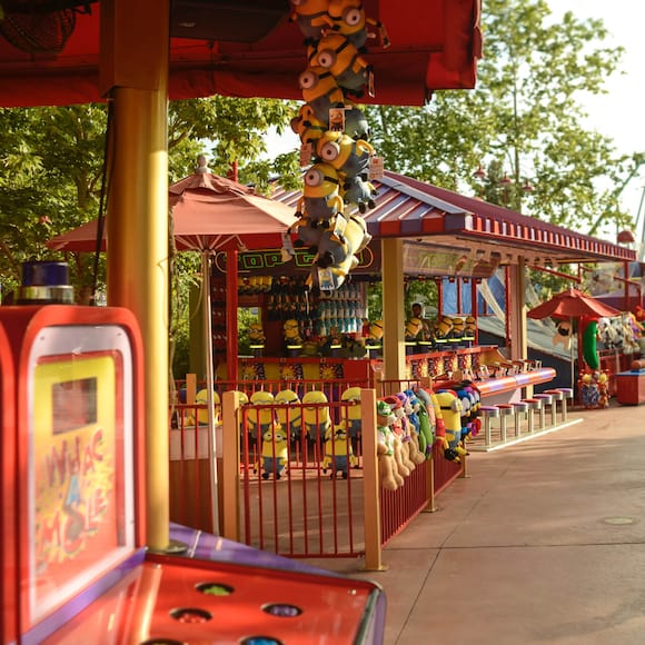 A row of red and purple carnival games, such as Whac A Mole and Top Glo, makes up Toon Lagoon Games at Universal Orlando.