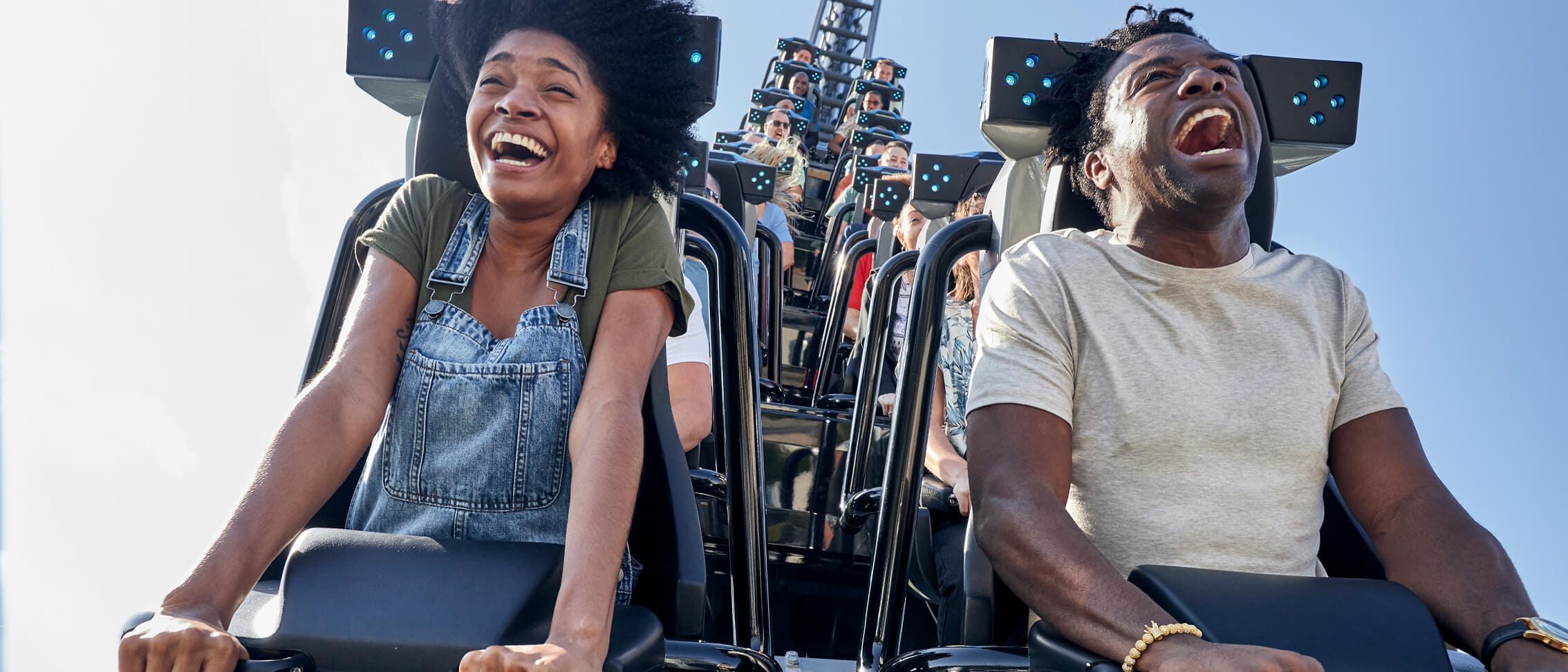 A couple screaming with joy on a roller coaster.