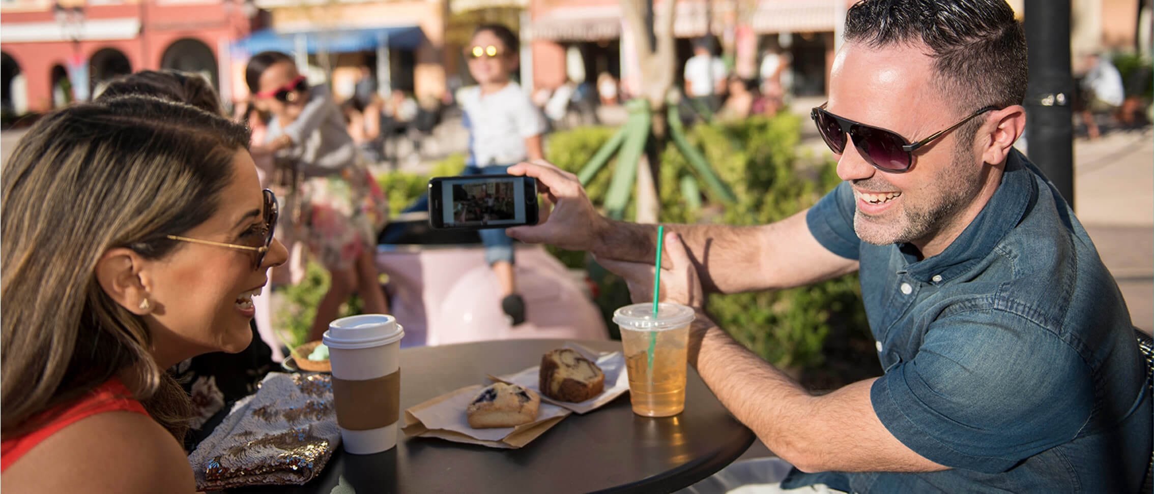 A couple snaps a selfie while enjoying coffee at Caffe Espresso in Loews Portofino Bay Hotel at Universal Orlando Resort.