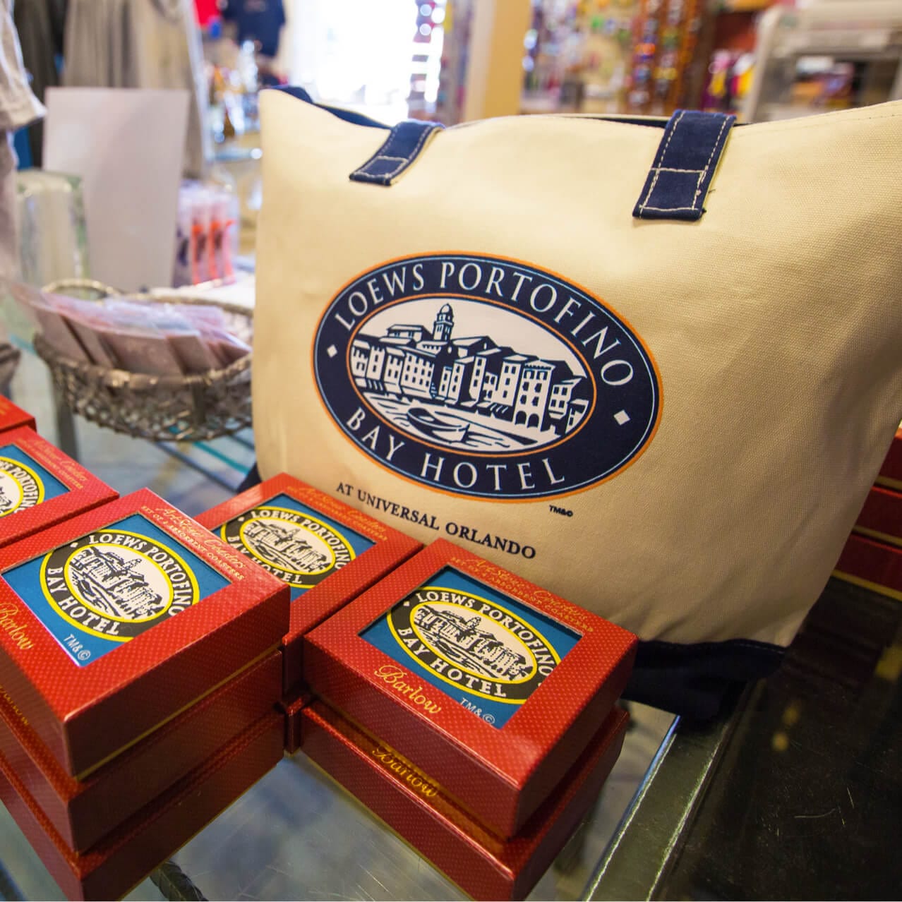 Tote bags and coasters with the Loews Portofino Bay Hotel logo on them for sale at Le Memories de Portofino gift shop at Universal Orlando.
