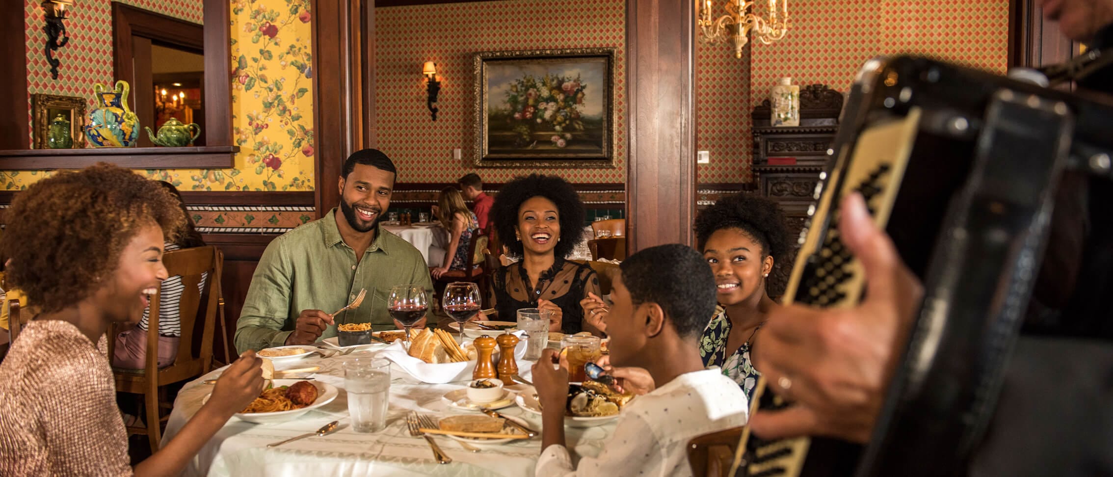 A musician plays alongside a family as they dine at Mama Della s Italian Ristorante at Loews Portofino Bay Hotel.
