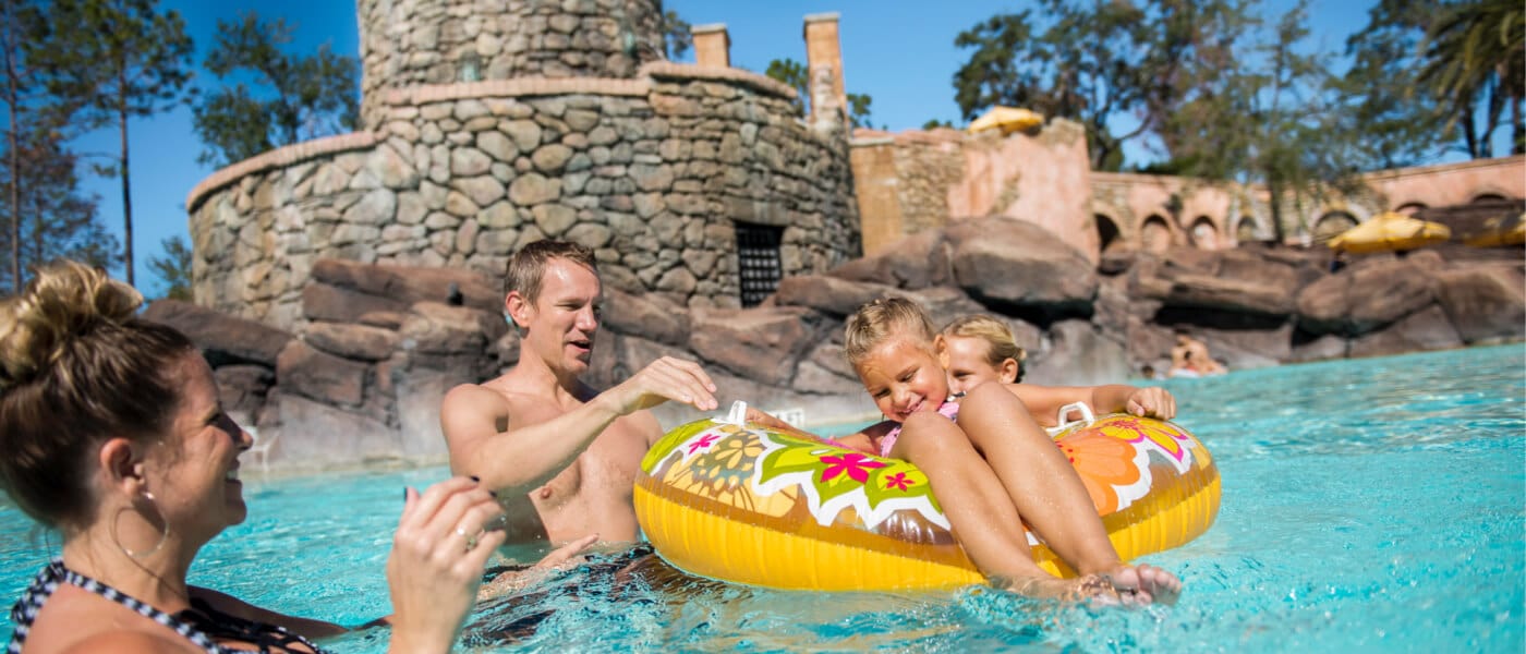 Two kids float in an inner tube as mom and dad stand nearby in the Portofino Bay Hotel pool at Universal Orlando.