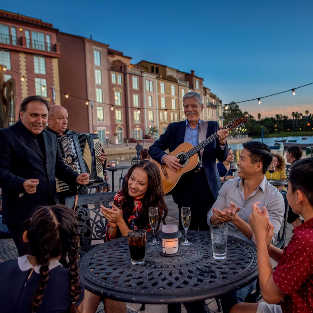 A family is serenaded as they dine alfresco at Loews Portofino Bay Hotel at Universal Orlando Resort.