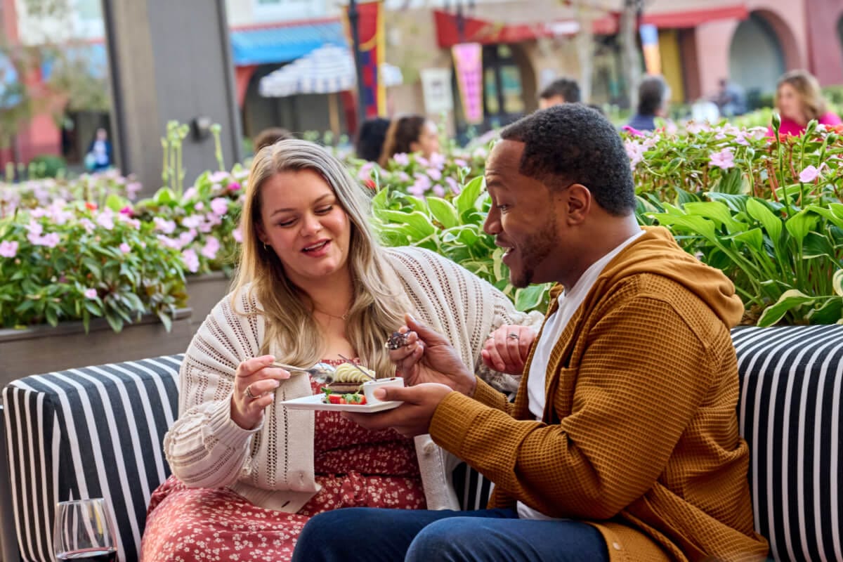 A couple enjoying a dessert and drinks together on the patio of Trattoria del Porto at Loews Portofino Bay Hotel.