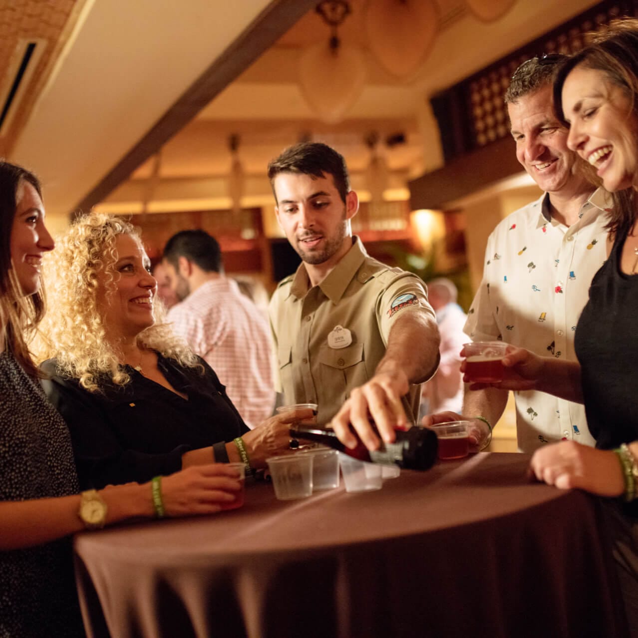 A server pours beer for a group gathered around a table during Jake's Beer Dinner.