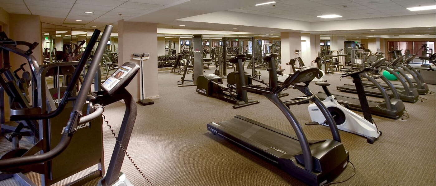 Rows of treadmills, elliptical machines, and other gym equipment fills the fitness center inside Loews Royal Pacific Resort at Universal Orlando.