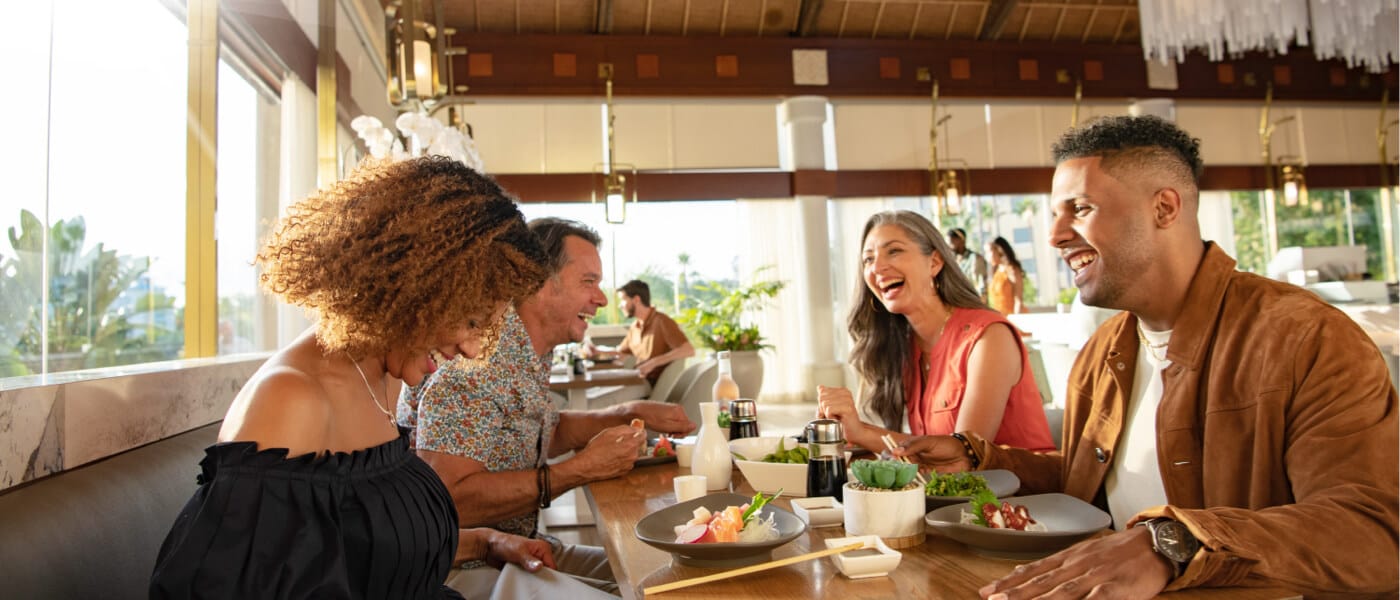 A group of guests enjoy food at Orchid Court Lounge & Sushi Bar at Loews Royal Pacific Resort.