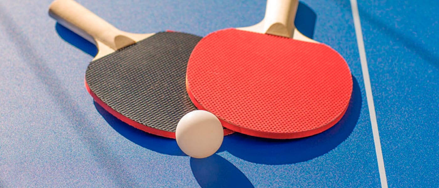 Two ping pong paddles and a ball.