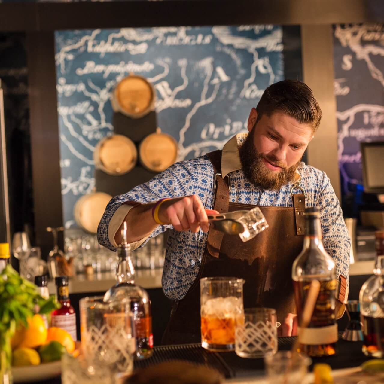 A bartender smiles as he prepares a drink at Strong Water Tavern, a dining location at Universal Orlando's on site hotel, Loews Sapphire Falls Resort.
