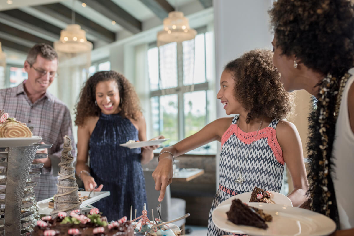 A family walks through a buffet line to enjoy their holiday snacks and beverages at Lowes Sapphire Falls Resort.