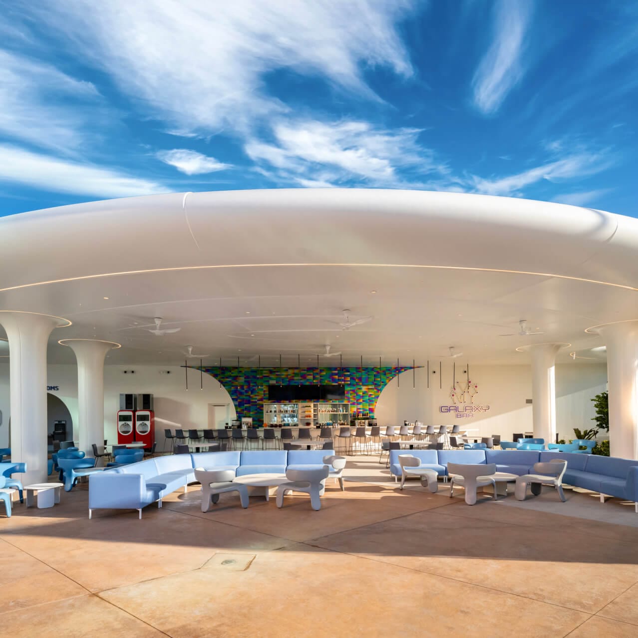 Wide view of the exterior of the Galaxy Bar and Galaxy Grill, with spacious seating and a long bar in the background.