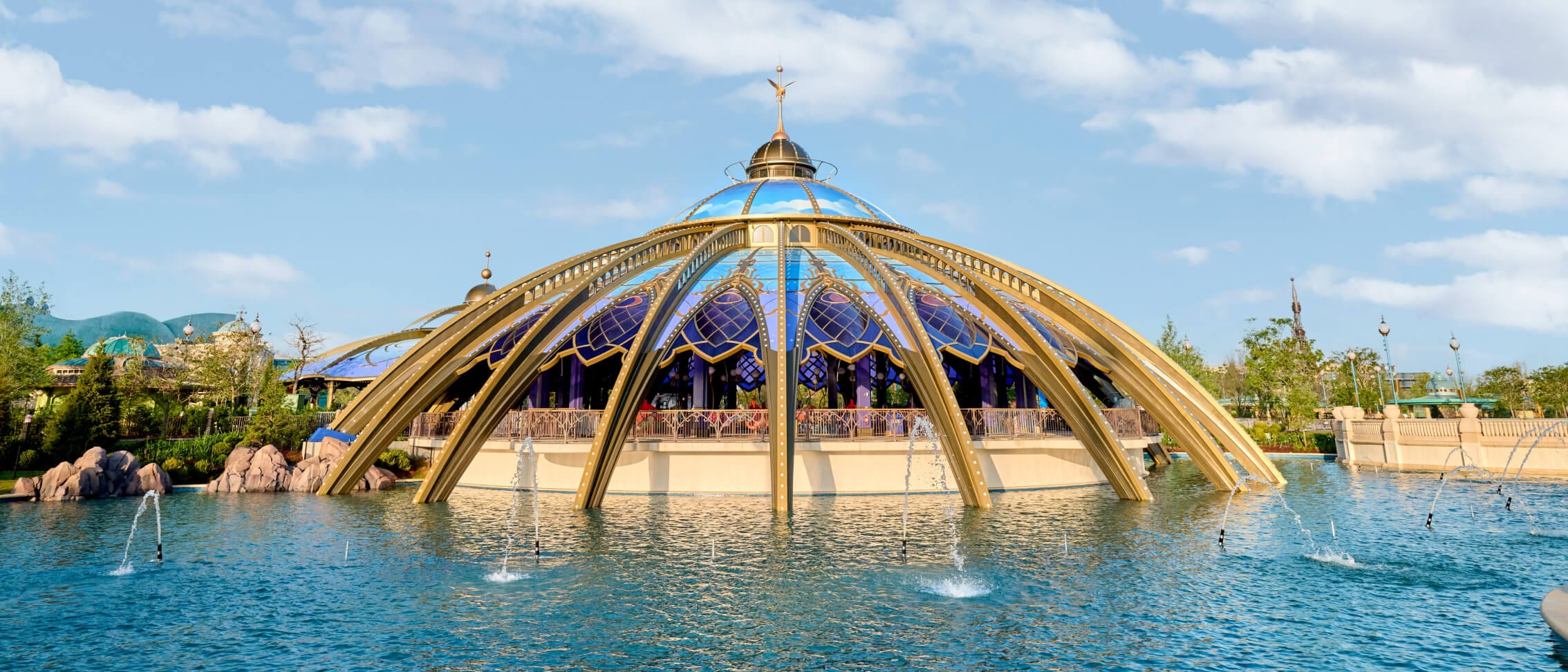 Constellation Carousel rises above the blue waters of Celestial Park in Universal Epic Universe.