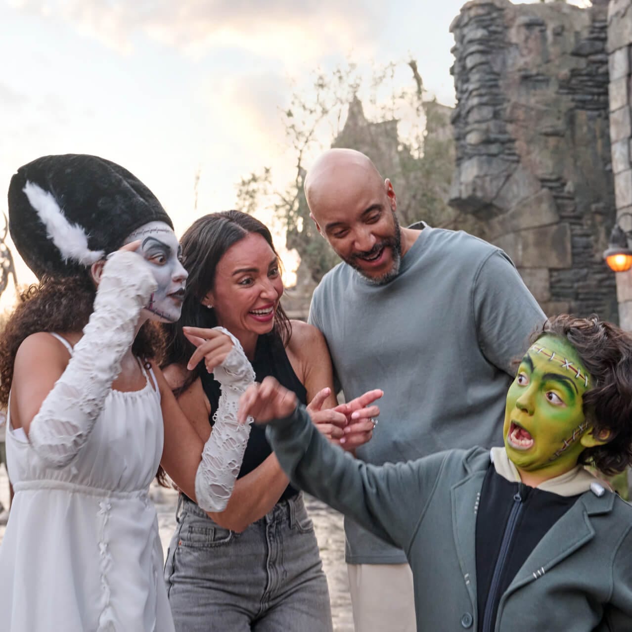Two children in full face makeup of Frankenstein's Monster and the Bride of Frankenstein joke and play with their family in Dark Universe.