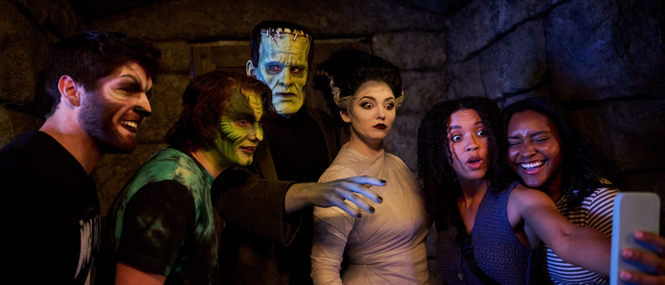Four guests take a photo with Frankenstein's monster and the Bride of Frankenstein in Dark Universe.